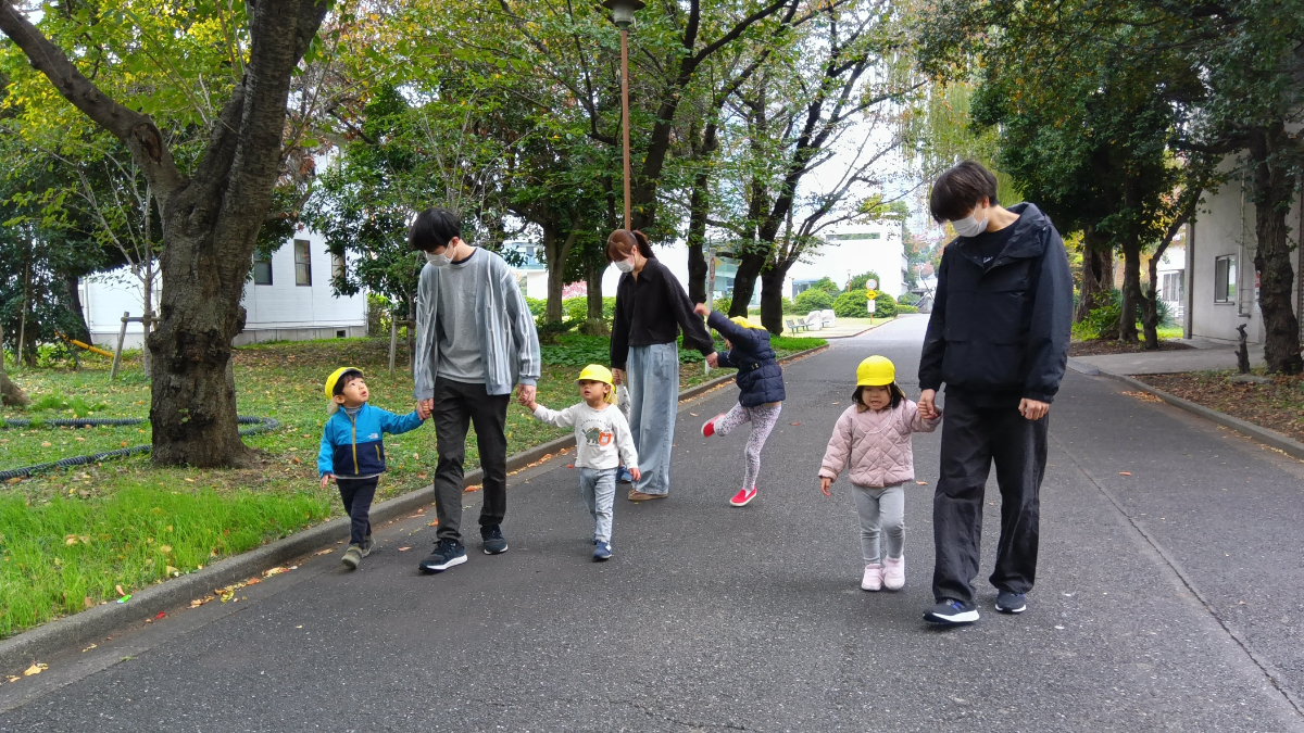 学生と手を繋いで歩く