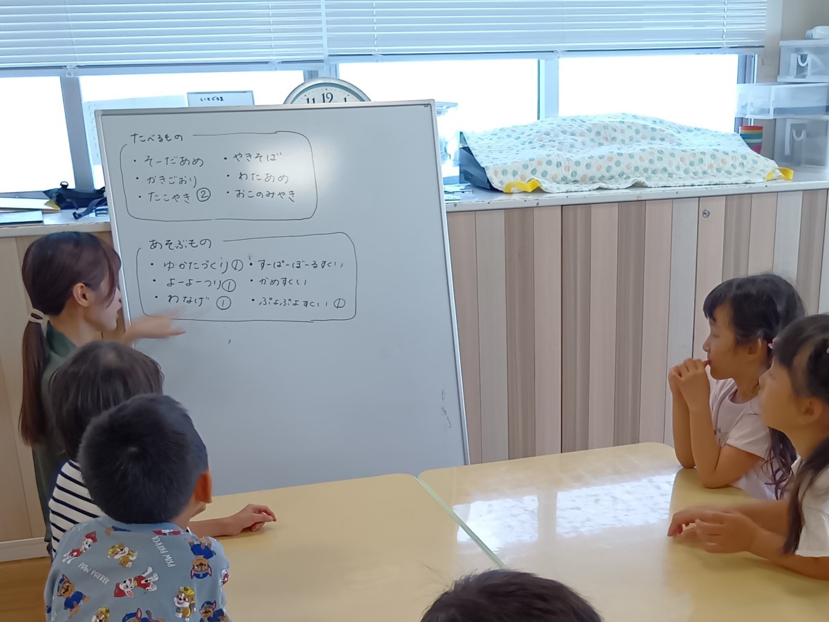 ホワイトボードにやりたいことを書いて会議する子どもたち