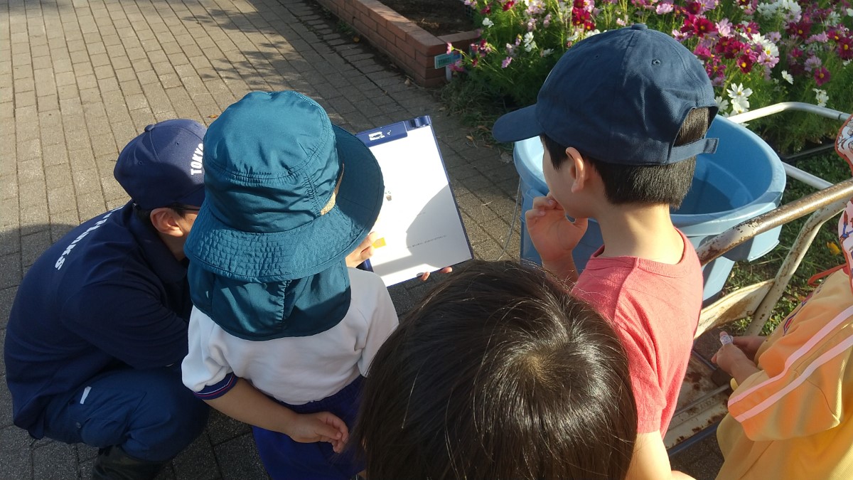 公園職員の方が子どもたちに資料を見せながら説明