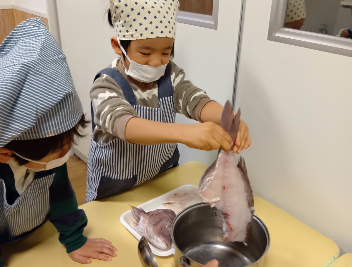鯛の開きを持ち上げる子ども