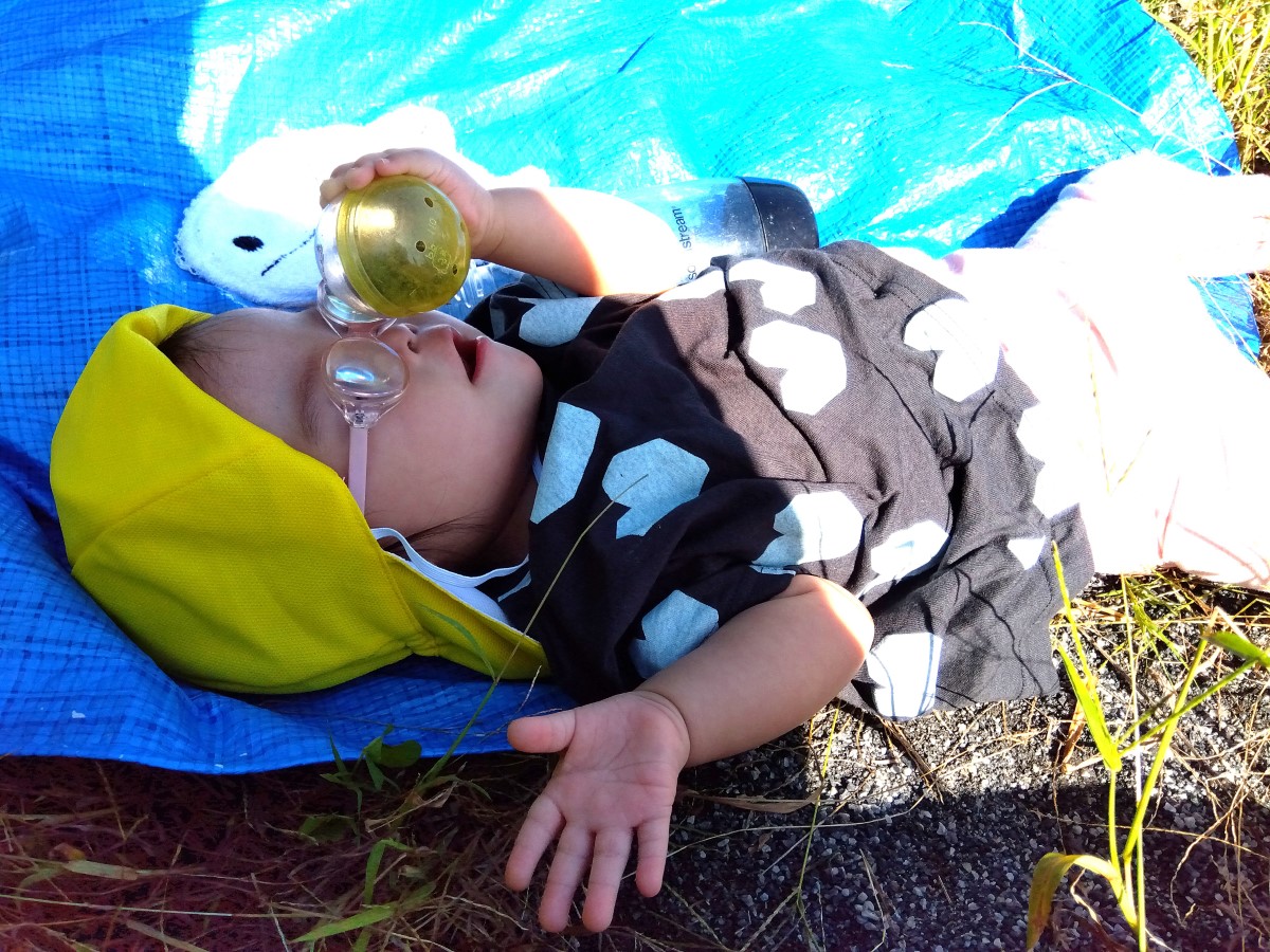 カプセルを手に寝っ転がる子ども