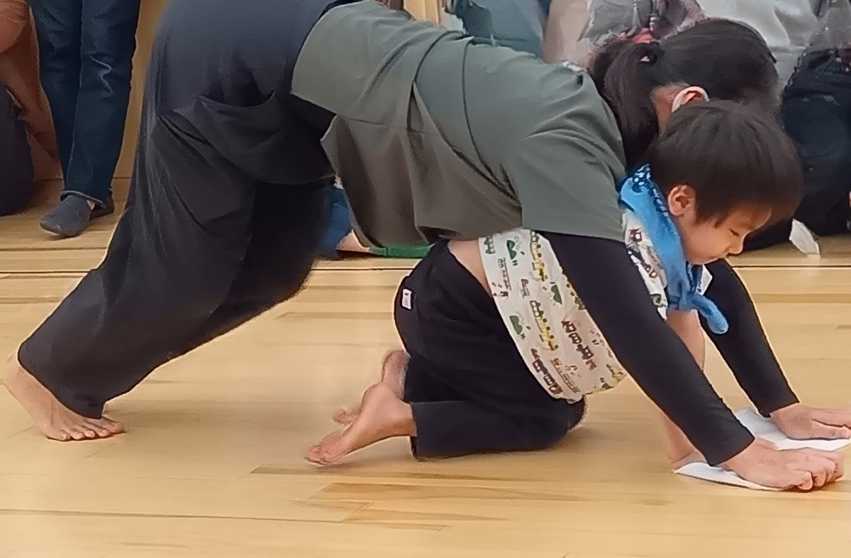 スタッフと一緒に雑巾がけを行う子ども