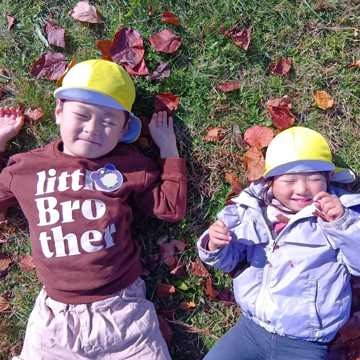 芝の上に寝っ転がる子どもたち