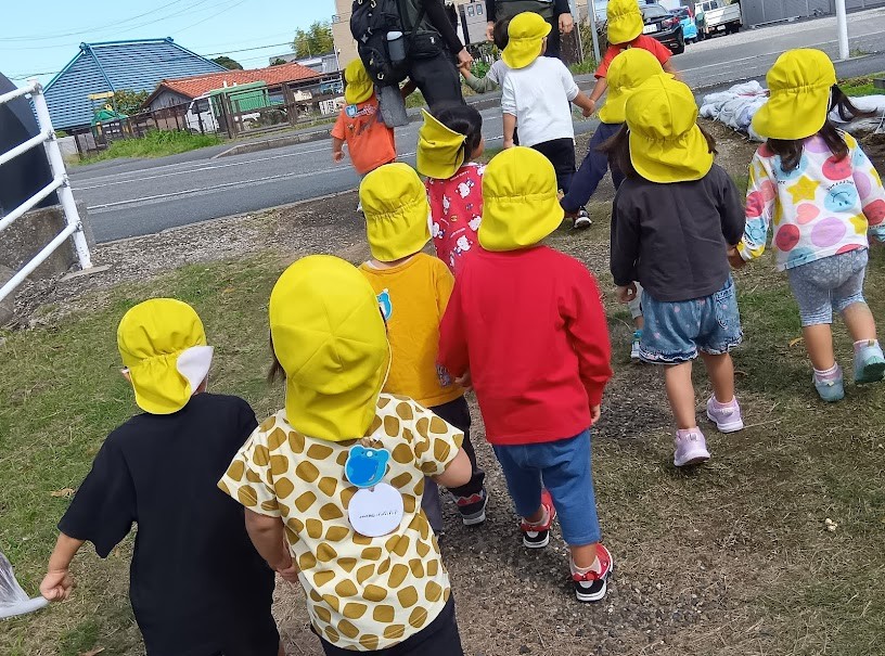 手をつないで散歩に出かける子どもたち