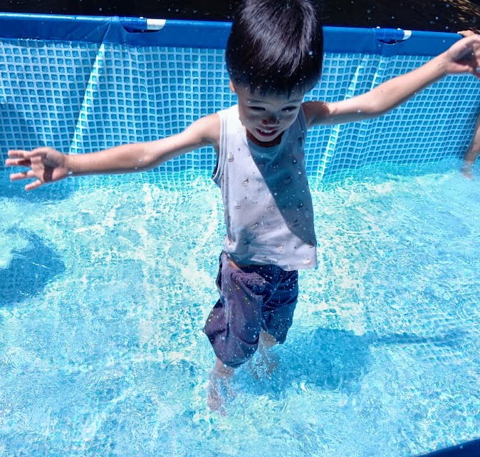 笑顔で水遊びをする子ども