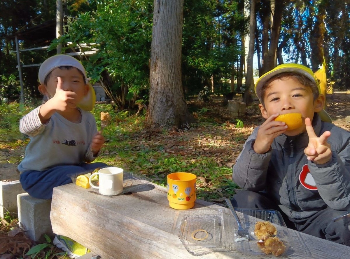 自然の中でお弁当を食べる子どもたち