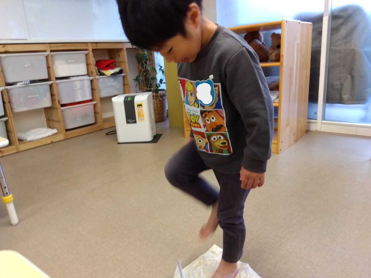 うどん生地を足で踏む子ども