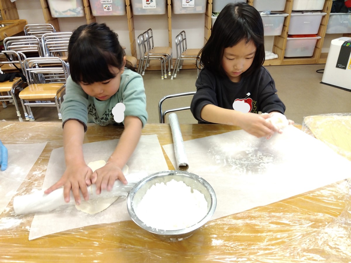 麺棒で記事を伸ばす子どもたち