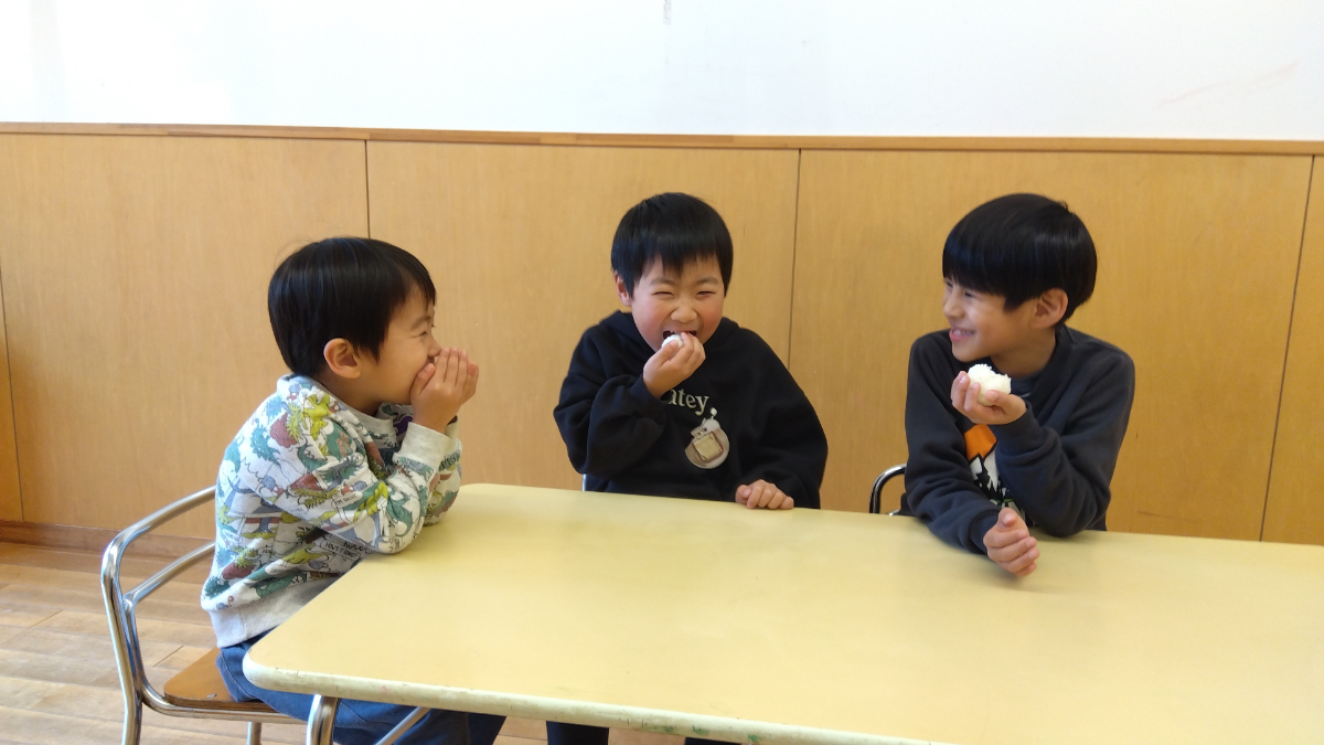 おにぎりを笑顔で頬張る