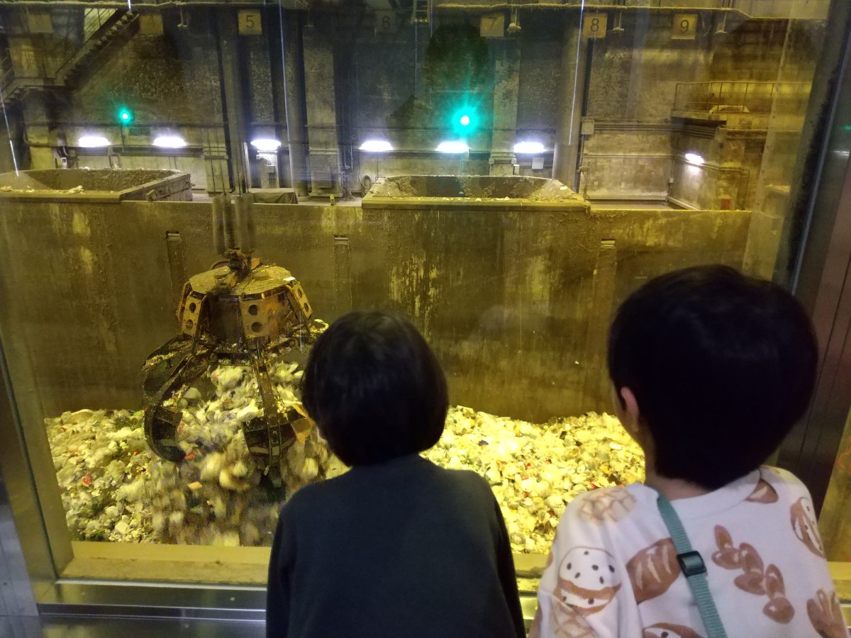 クレーンでゴミが持ち上げられる様子を見る子どもたち