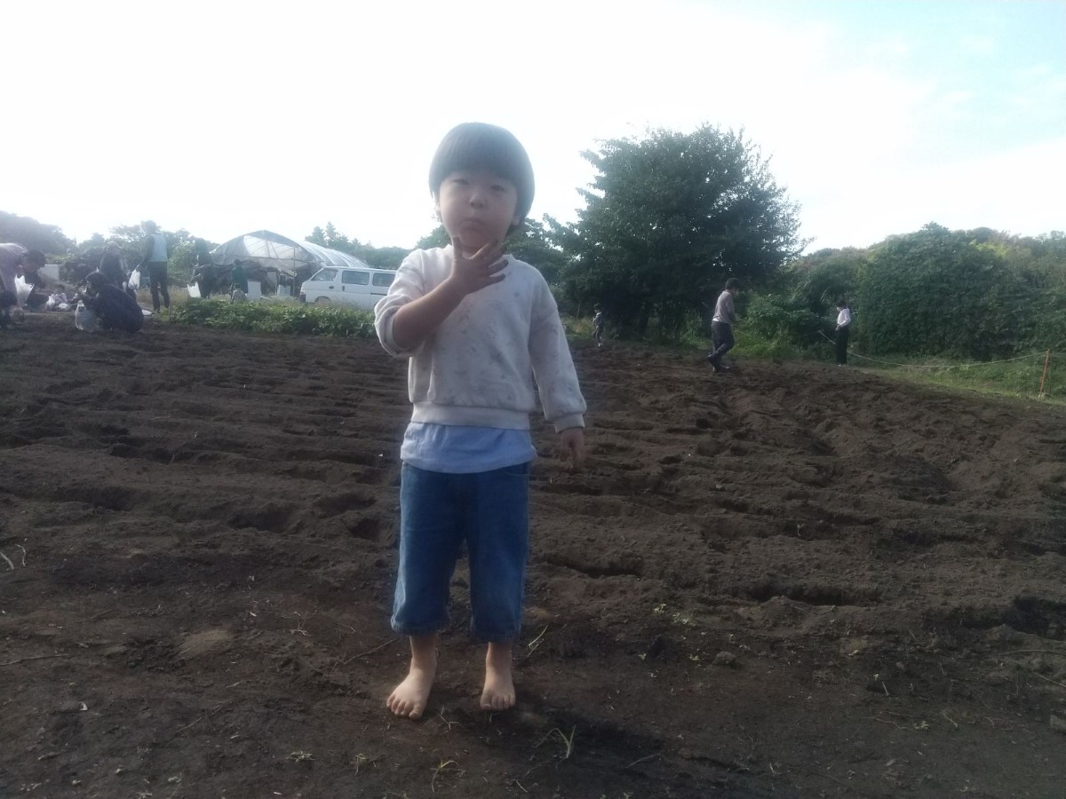 畑に裸足で立つ子ども