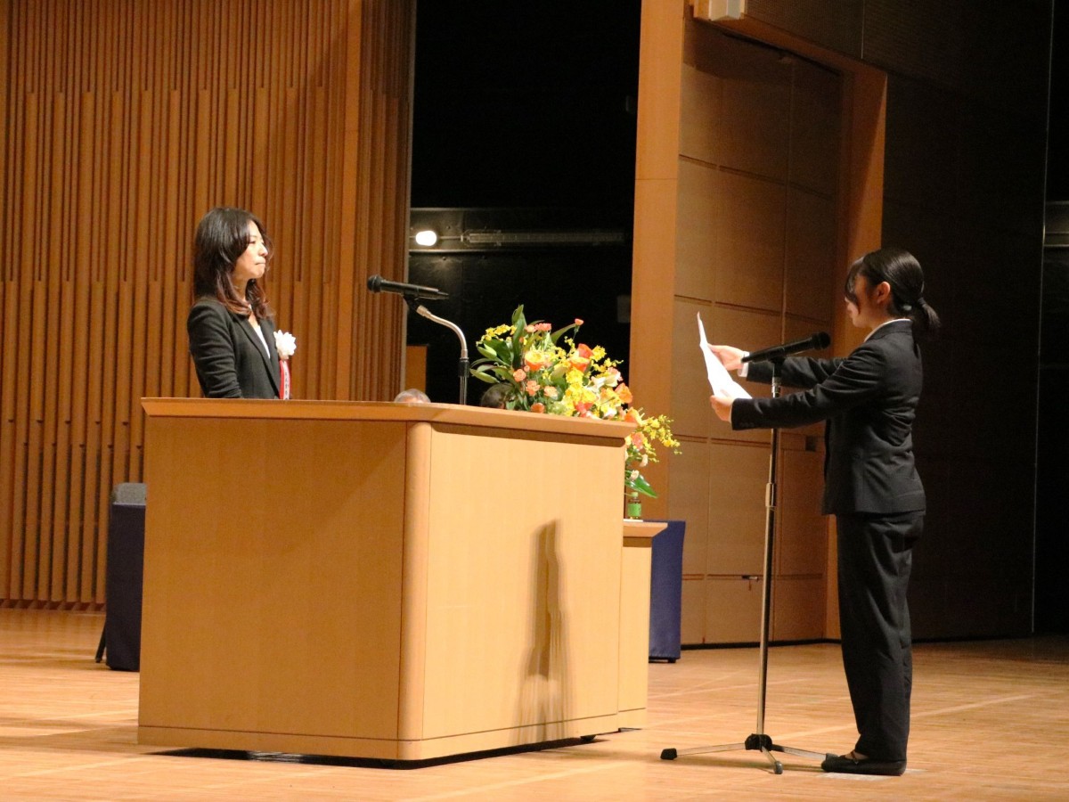 壇上で安永理事長を前に保育士代表として挨拶した斎藤さん