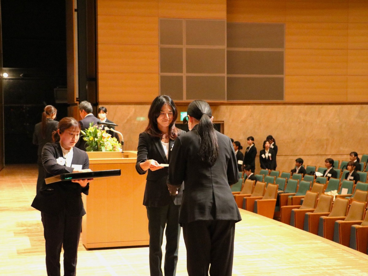 壇上で内定証書を受け取る内定者