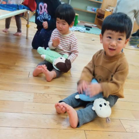 人形を膝の上で抱っこする子どもたち