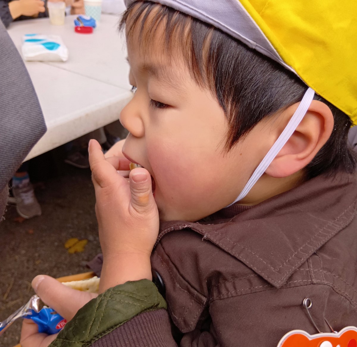 クラッカーにバターをつけて食べる子ども