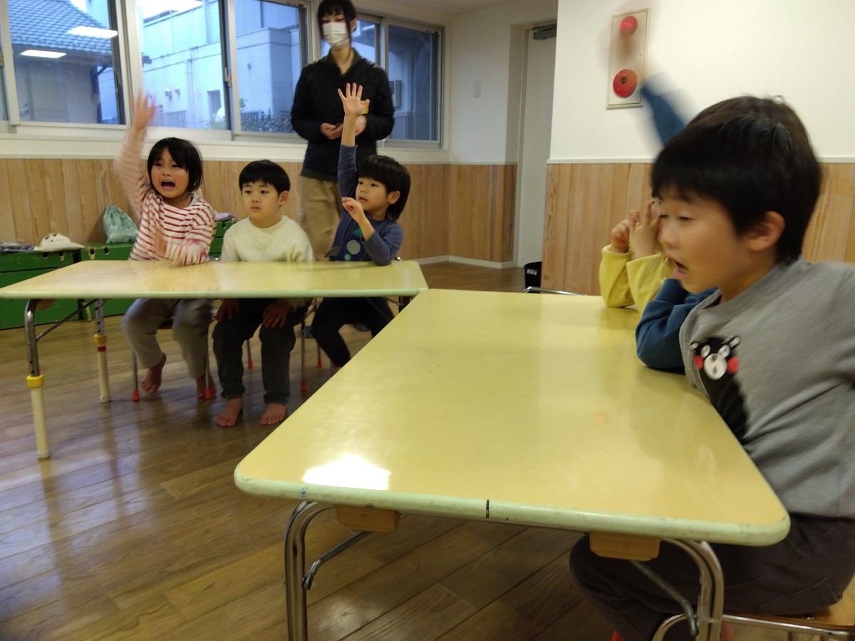 クイズに答えようと手を挙げる子どもたち