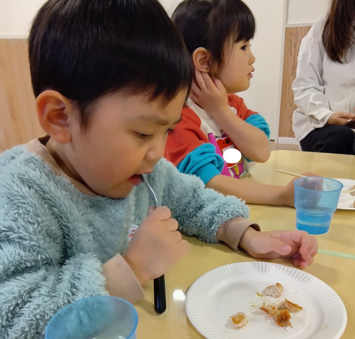 焼いた鶏肉を食べる子どもたち