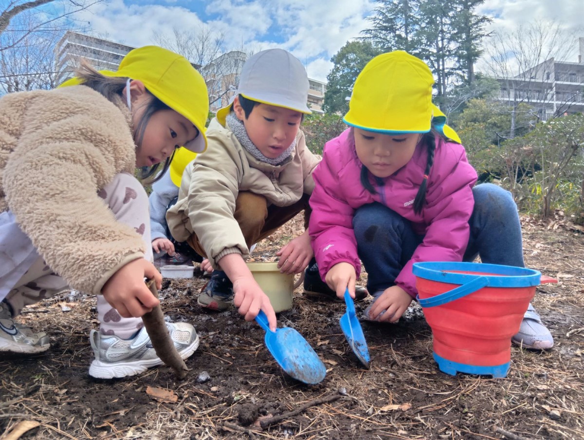 スコップで土を掘る子どもたち