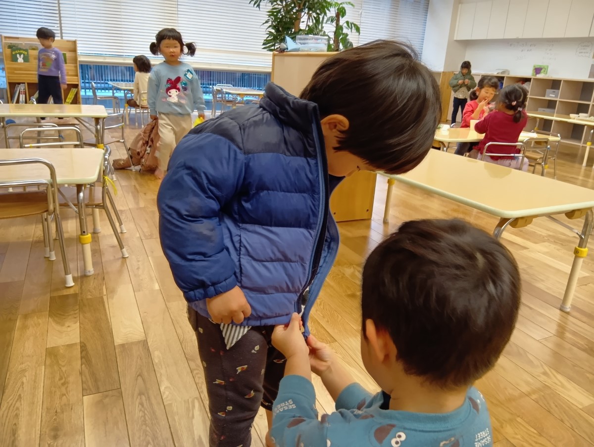 上着のファスナーをしめてあげる様子