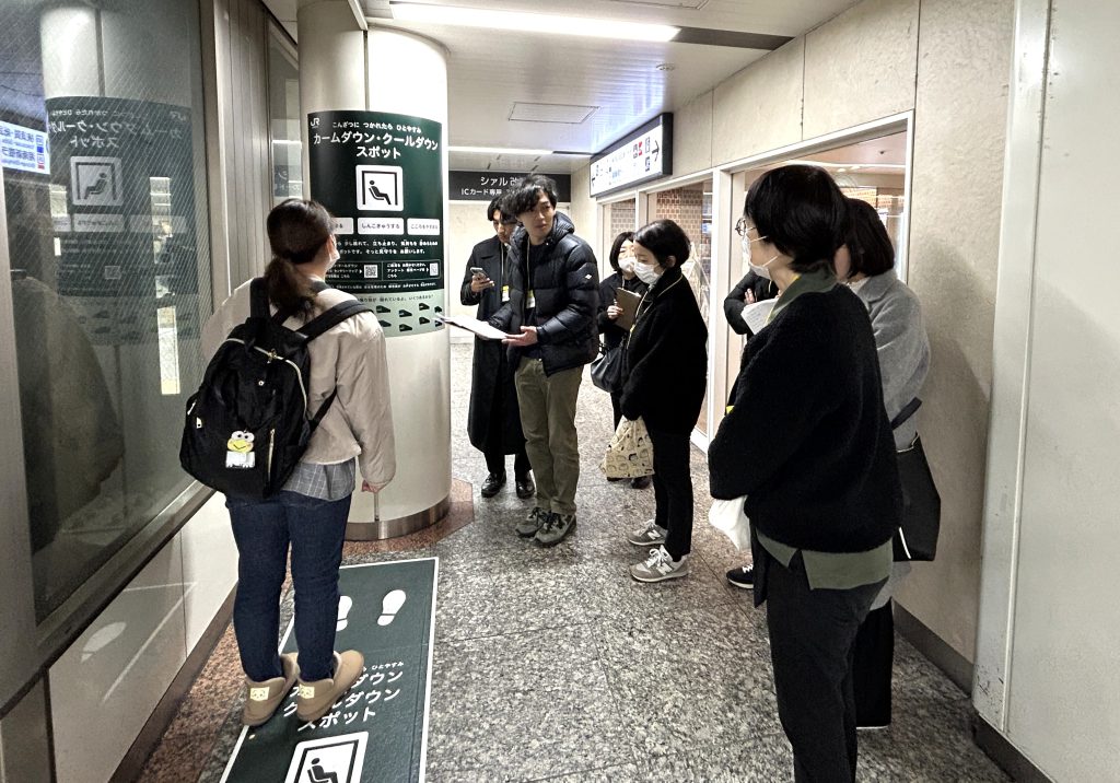 エレベーター横のスポットを確認する参加者たち