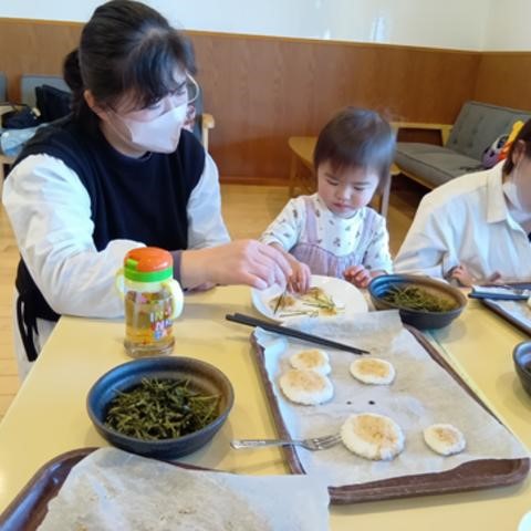 五平餅に刻みのりを振りかける子ども