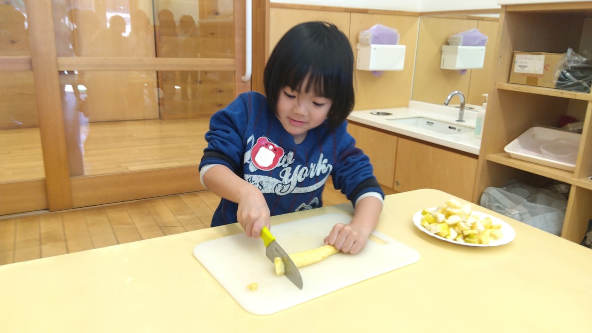 包丁でたくあんを切り分ける子ども