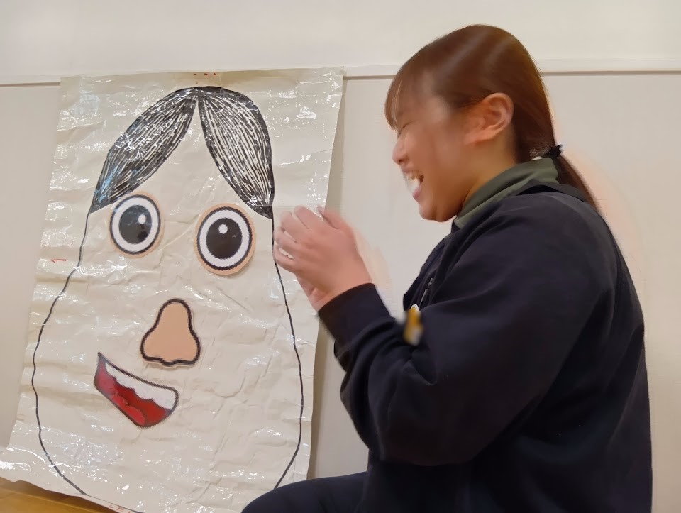 完成した福笑いを壁に飾る様子