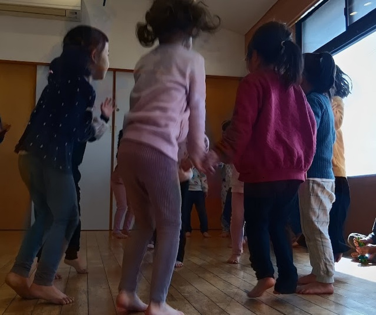 室内でかごめかごめを行う子どもたち
