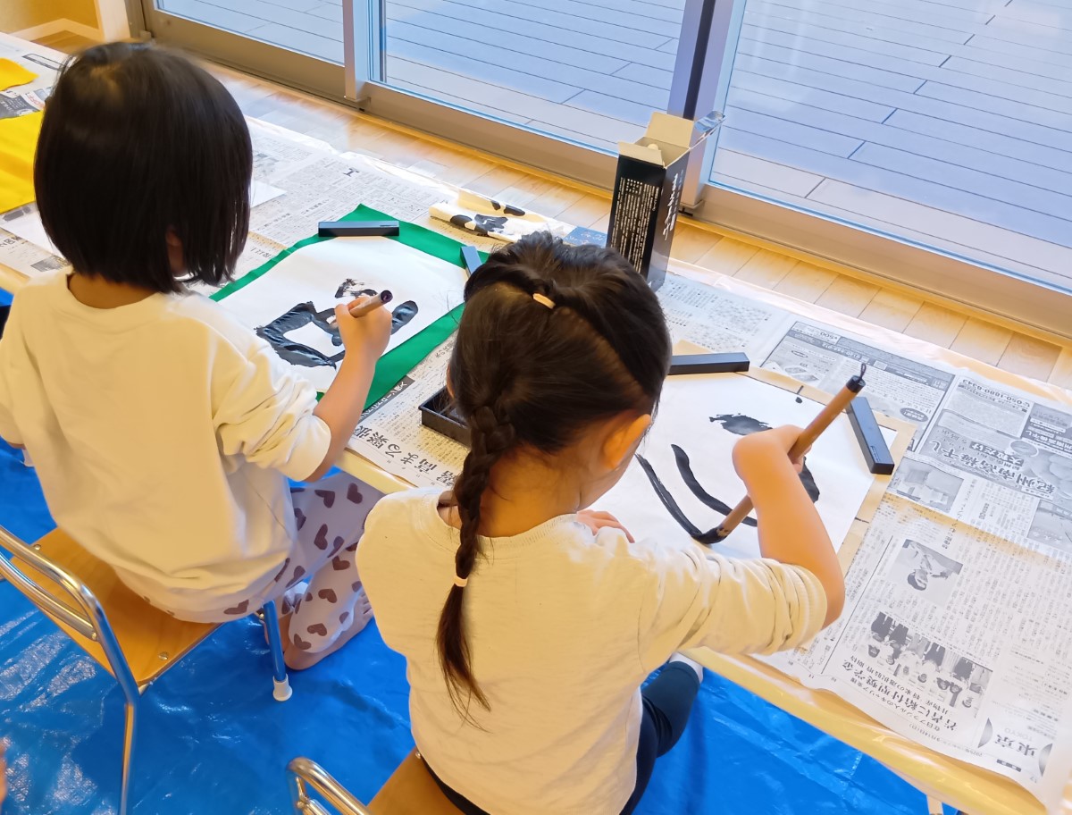 筆で線を描く子どもたち