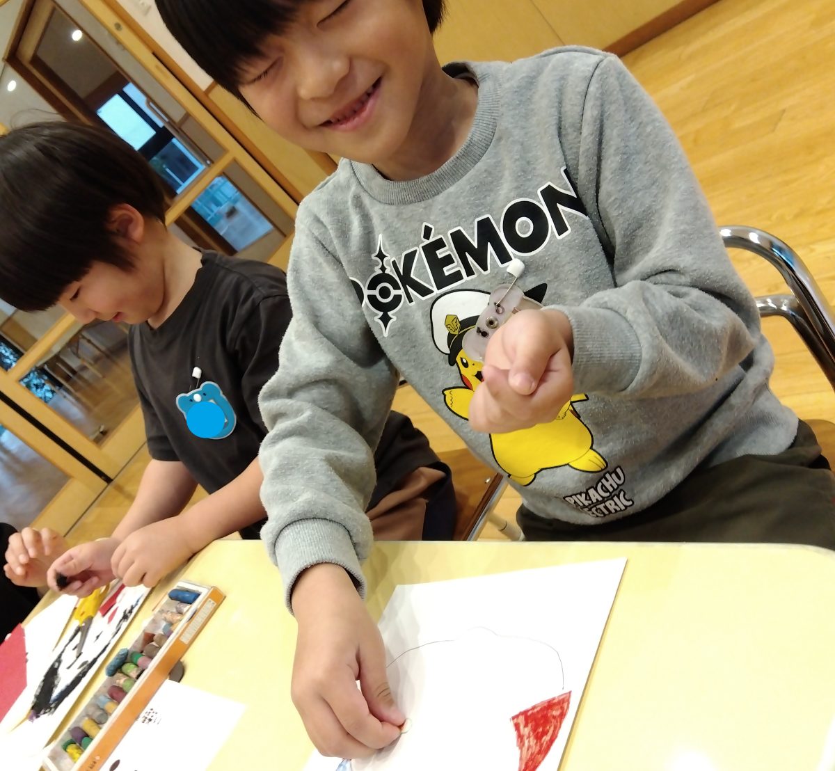 目を閉じて福笑いに挑戦する子ども