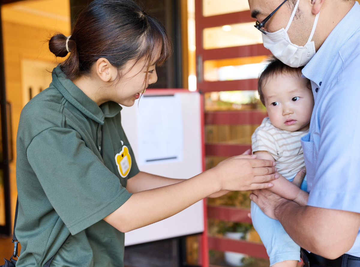 子どもに手を差し伸べる保育者
