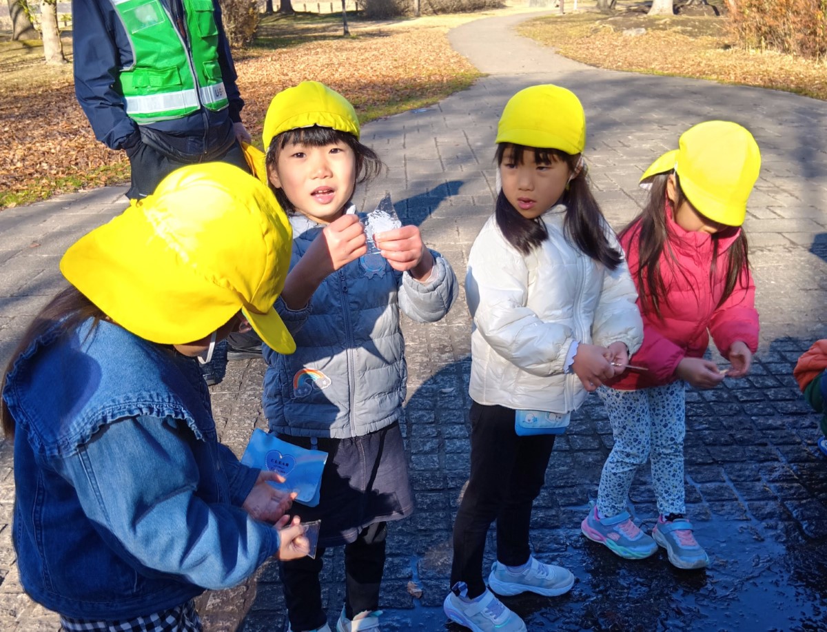薄い氷を手に持つ子どもたち
