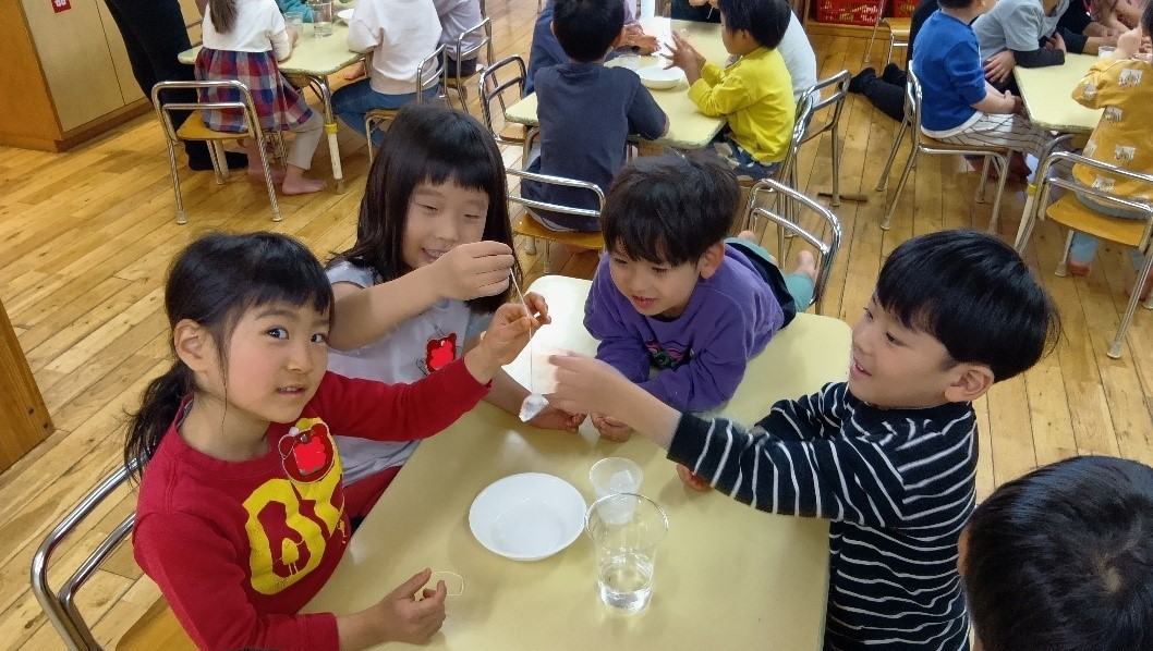 紐で氷を釣る子どもたち