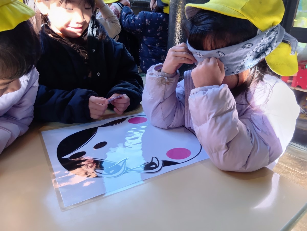 目隠しをして福笑いをする子どもたち