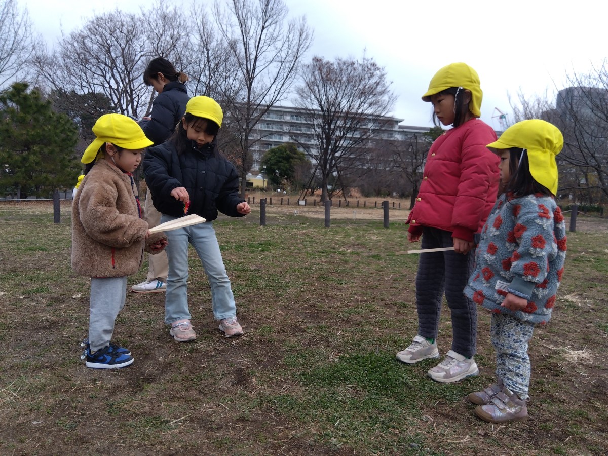 羽根つきのやり方を教え合う子どもたち