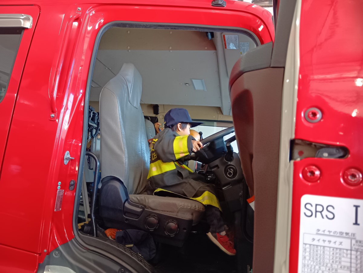消防車の運転席に座る子ども