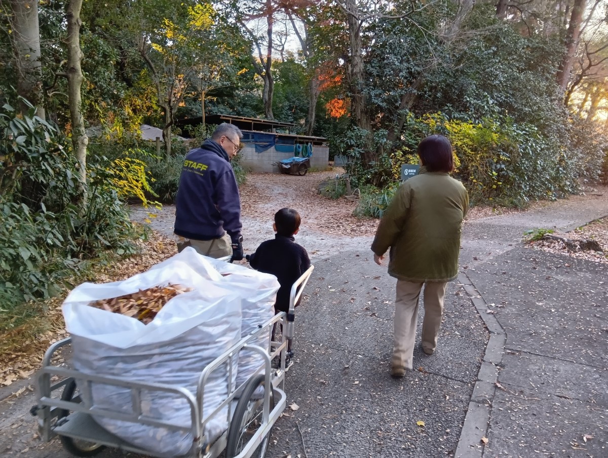 集めた落ち葉を運ぶ子ども
