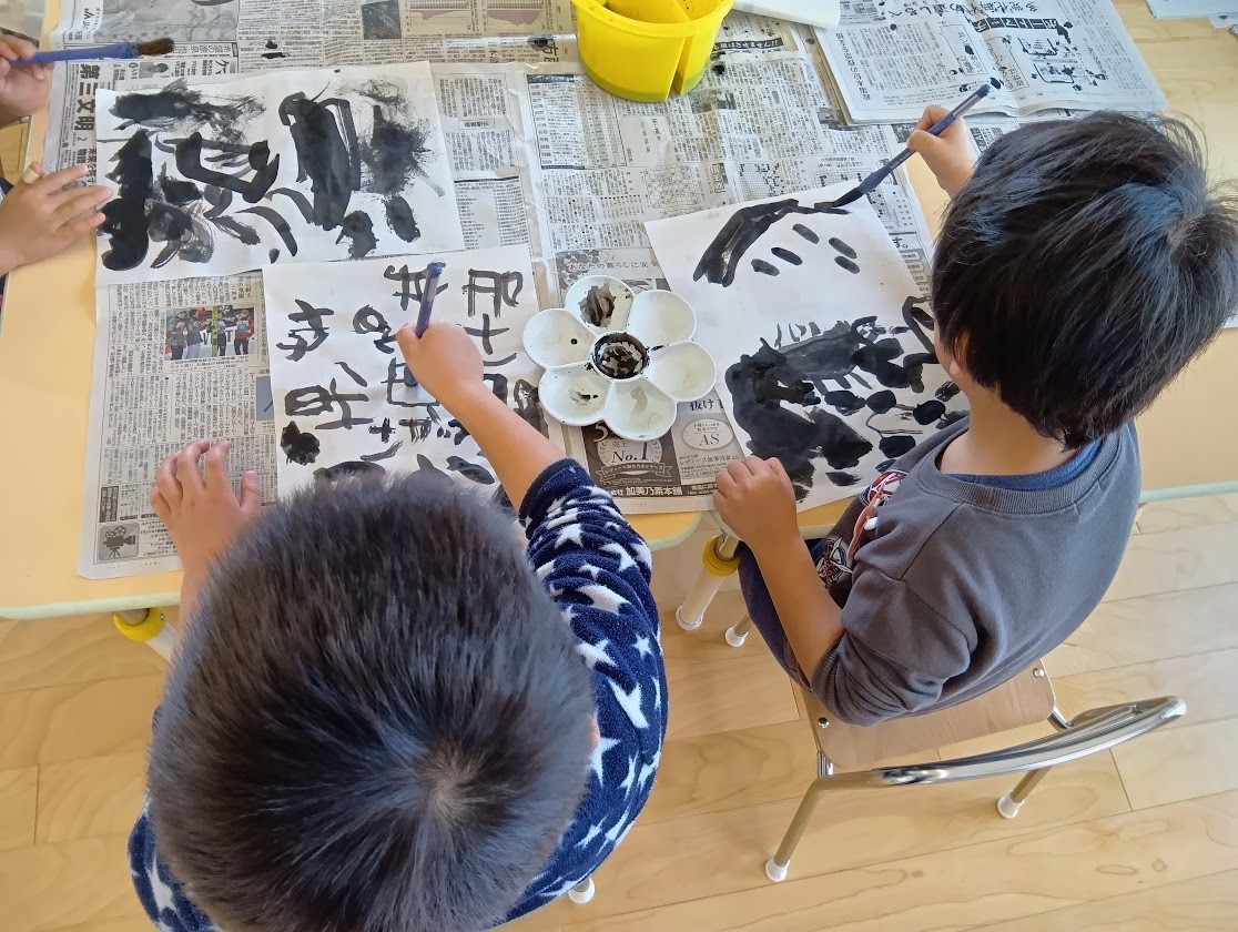 筆で文字を書く子どもたち