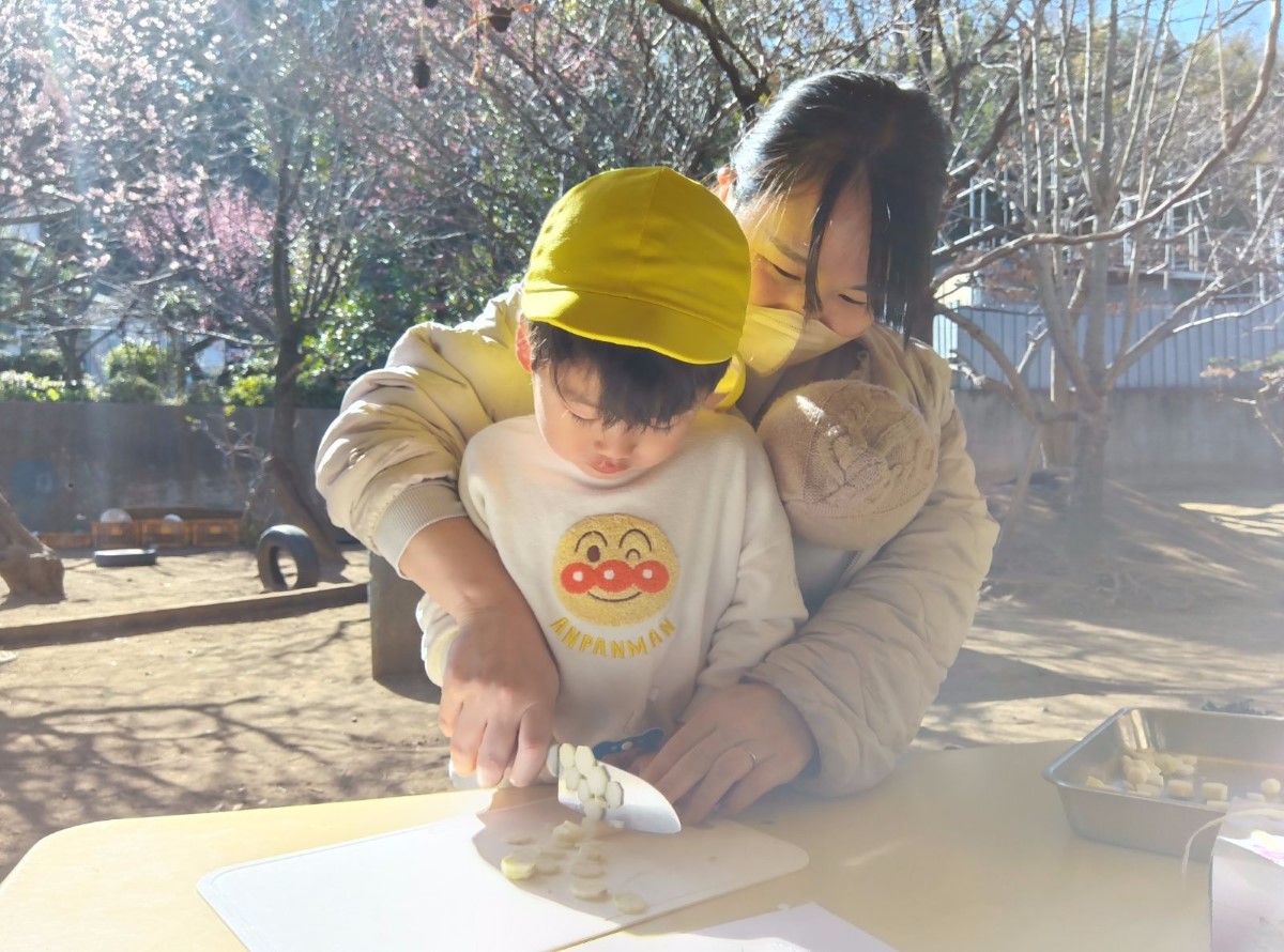 包丁を使って野菜を切る子ども