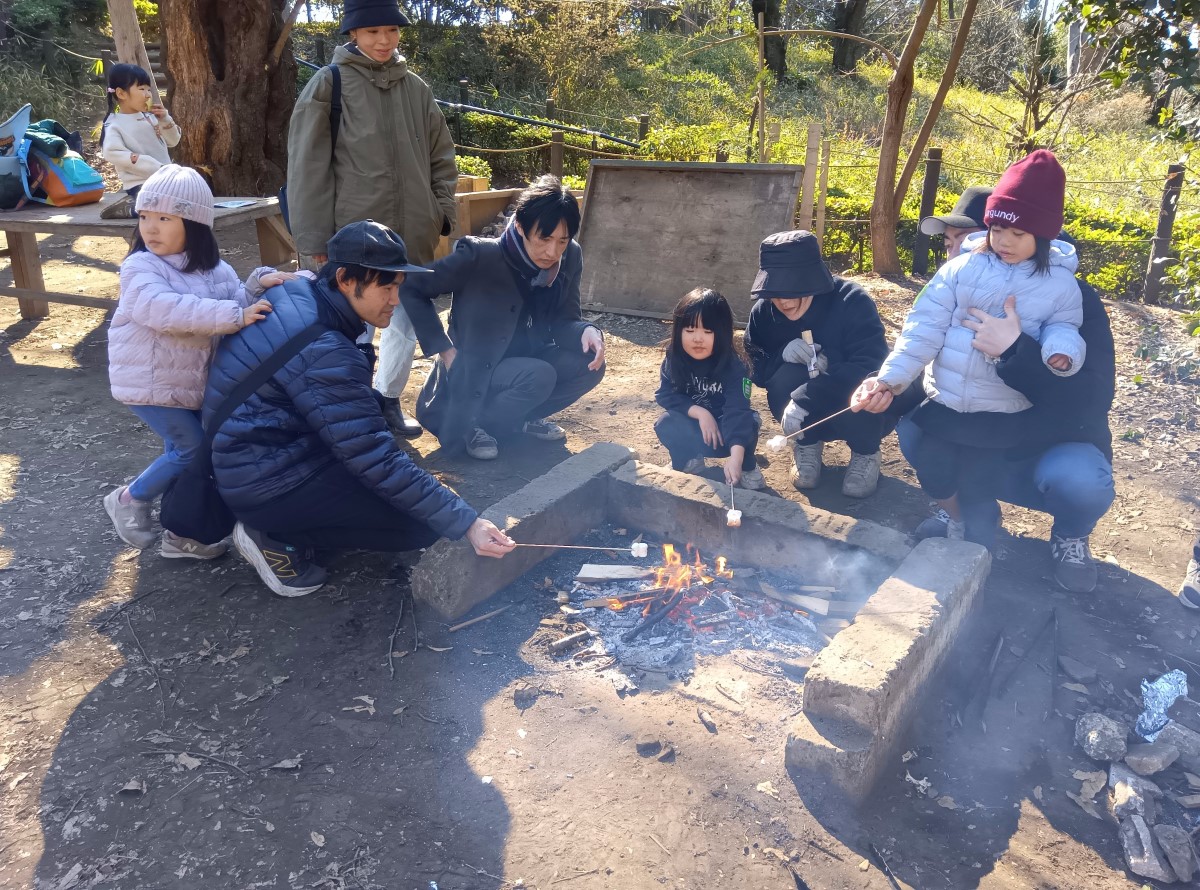 串にマシュマロを刺して焼く子どもたち