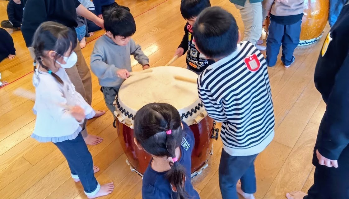 太鼓を囲んで叩く子どもたち