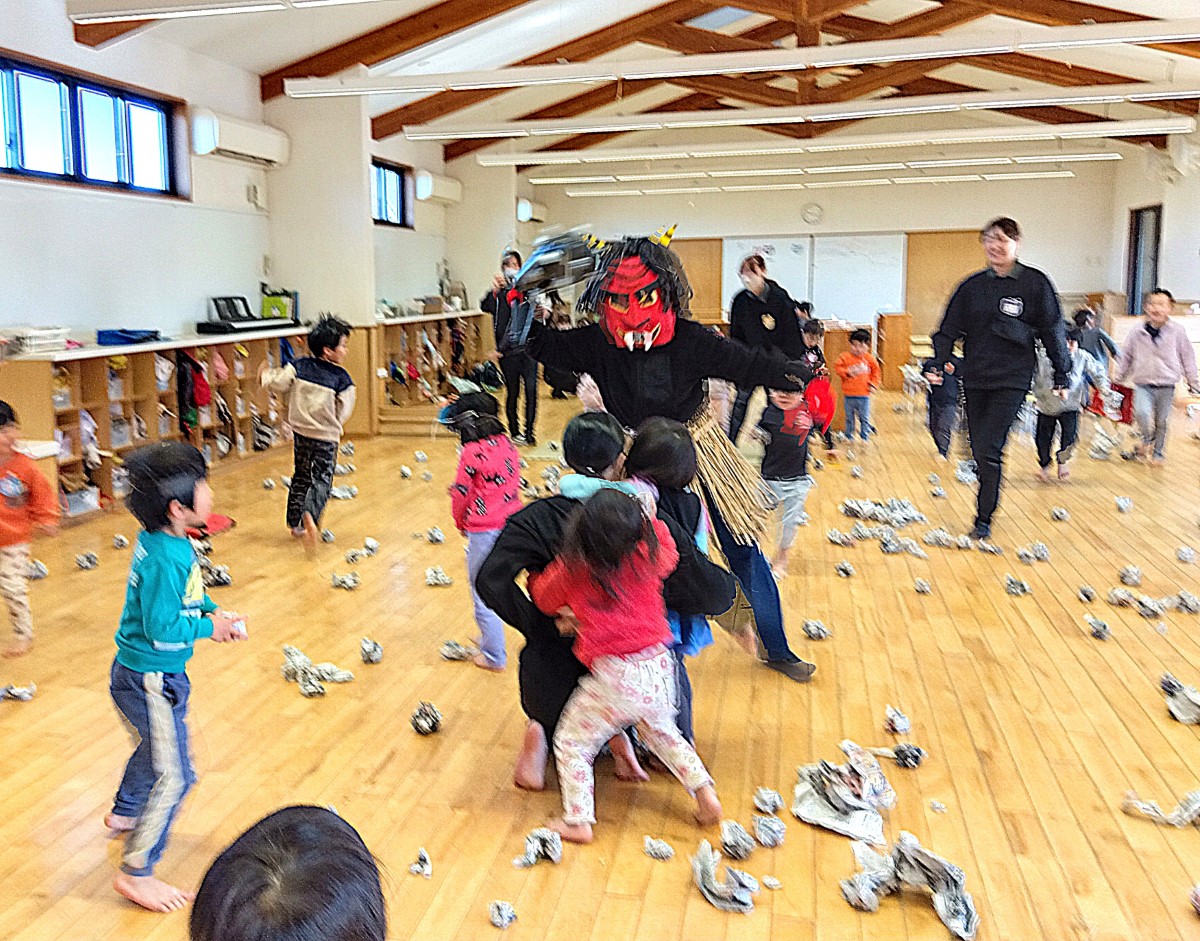 豆の代わりに丸めた新聞紙を投げる子どもたち