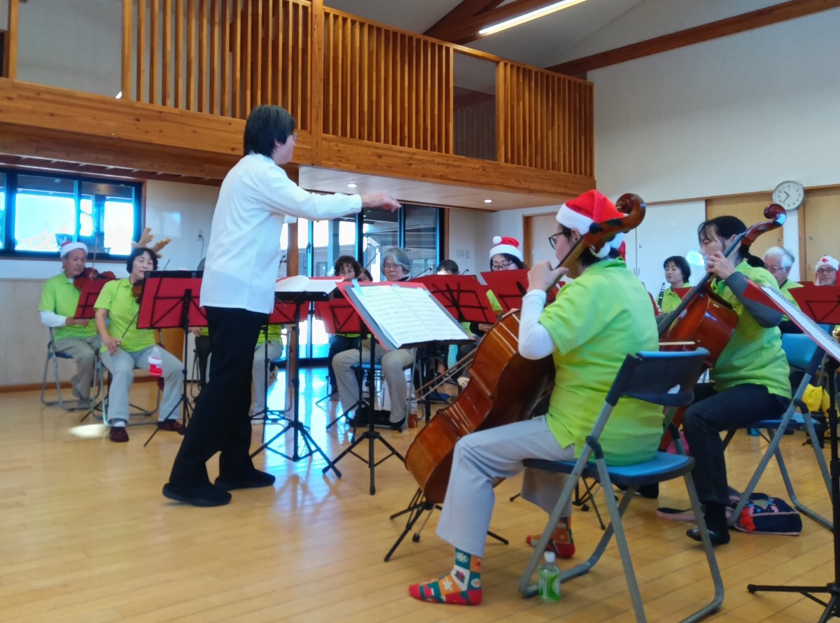 クリスマスの衣装を着て楽器を演奏する大人たち