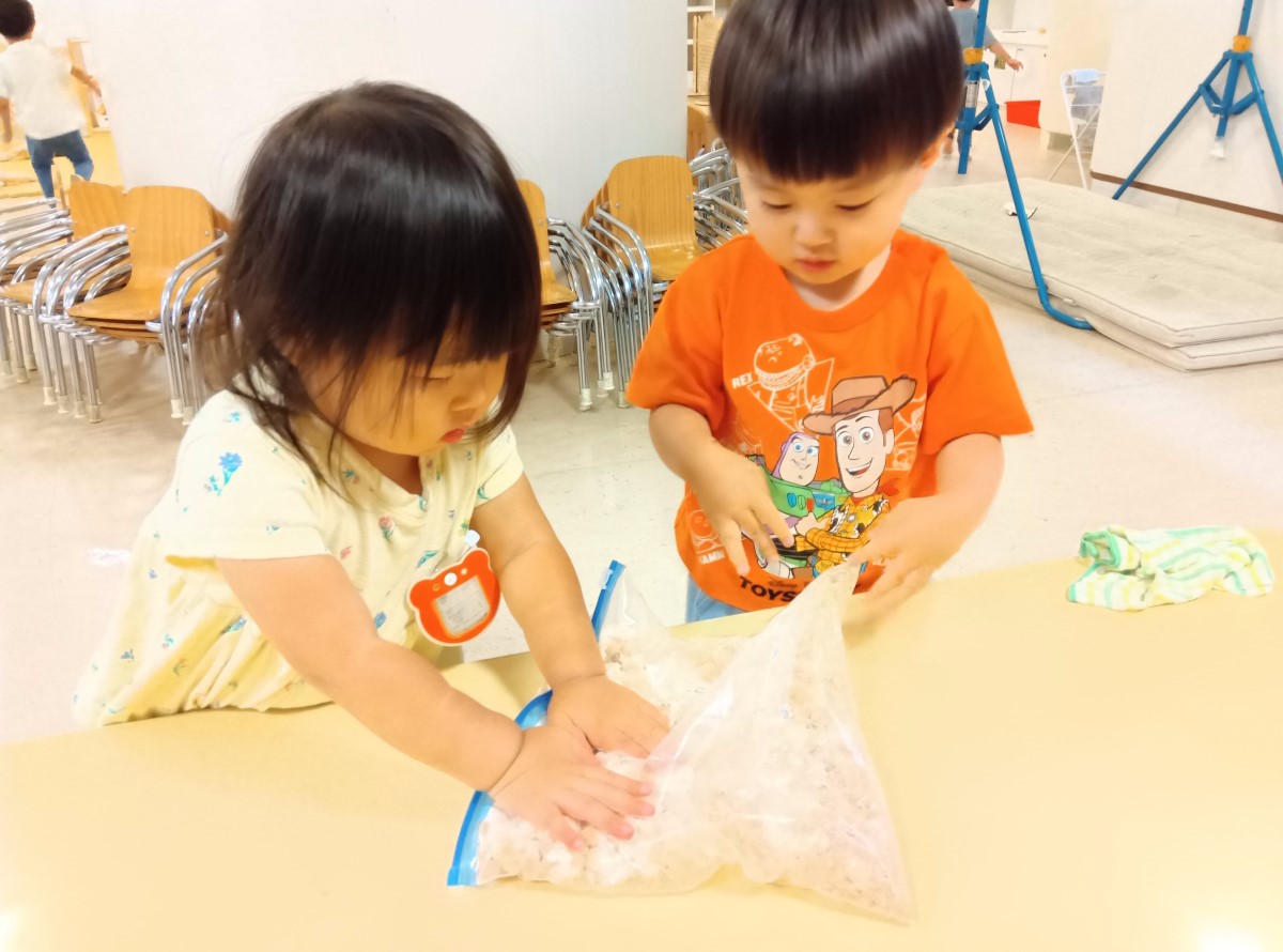 ポリ袋に大豆を入れて潰す子どもたち