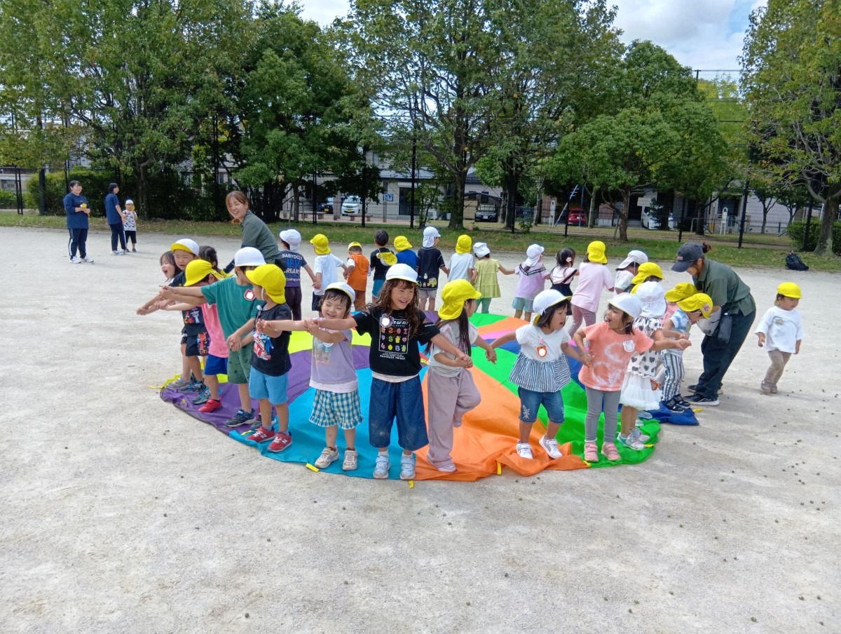 大人数で手をつないで輪になる子どもたち