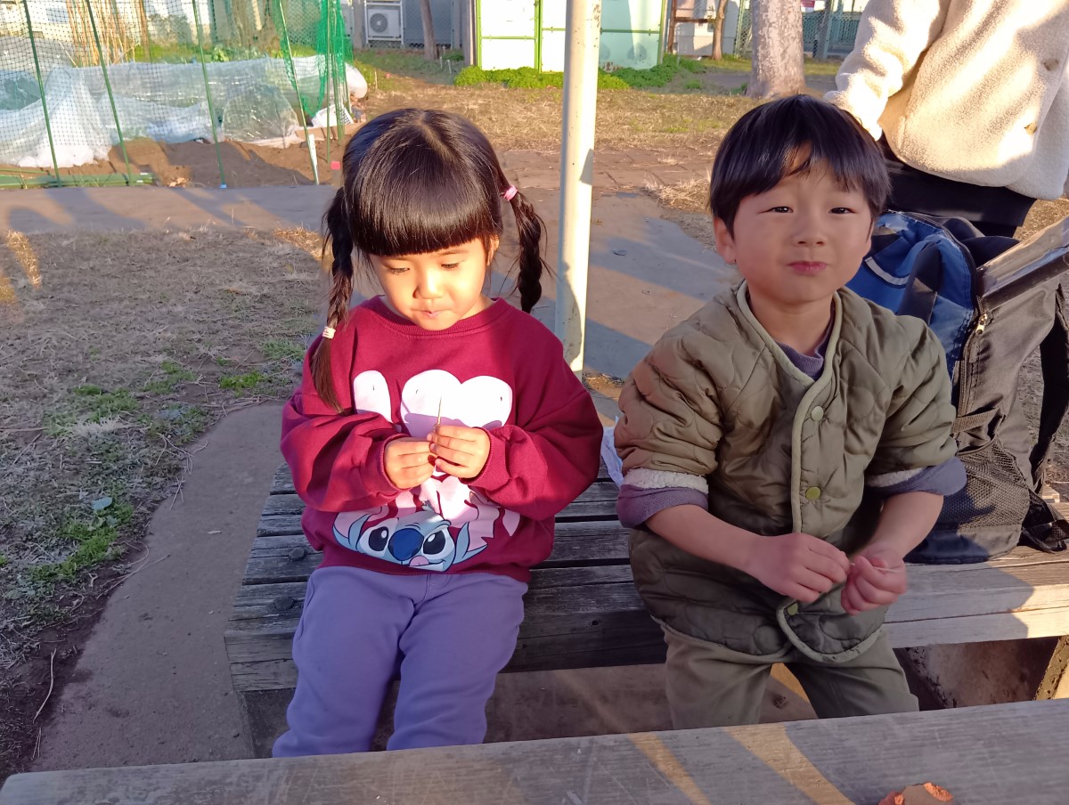 ベンチで大根を食べる子どもたち