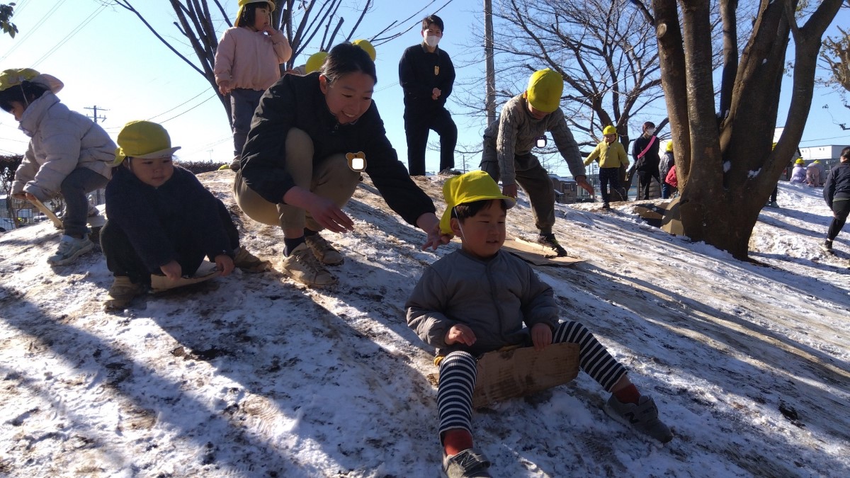 段ボール滑りをして楽しそうな子どもたち