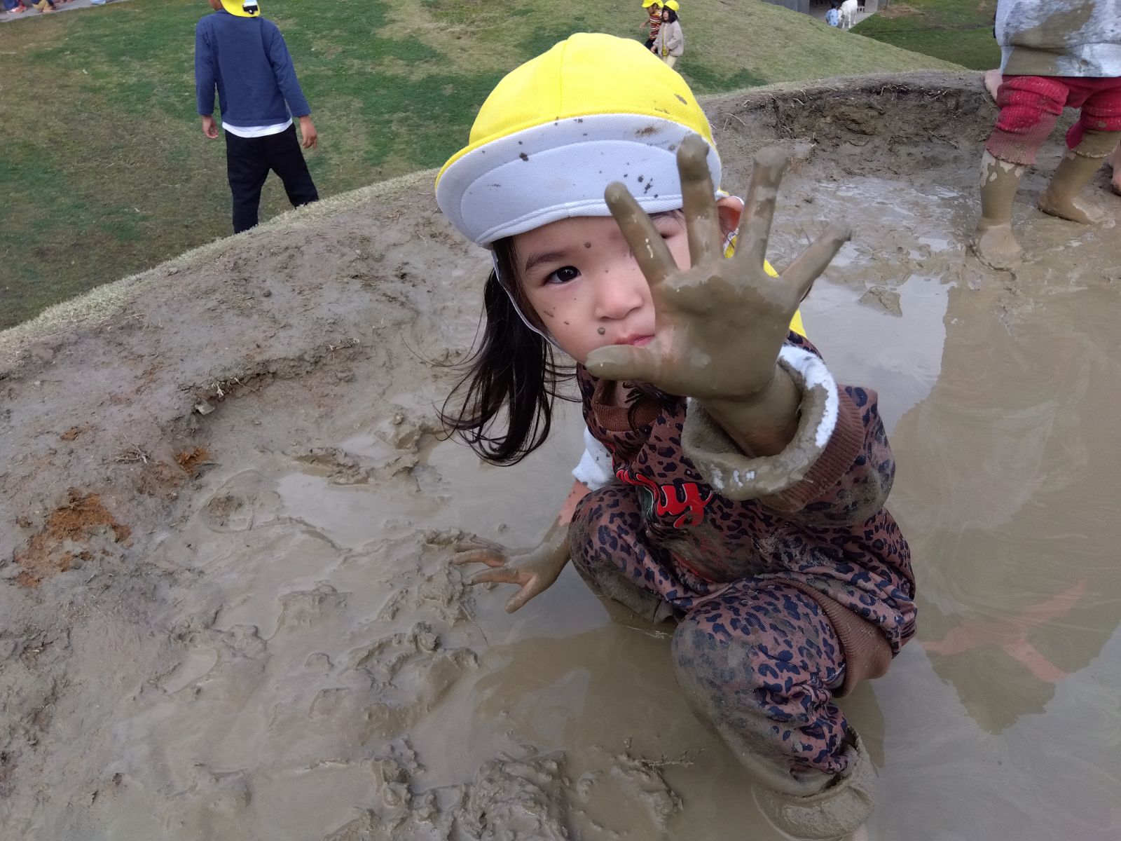 手に着いた泥を見せる子ども