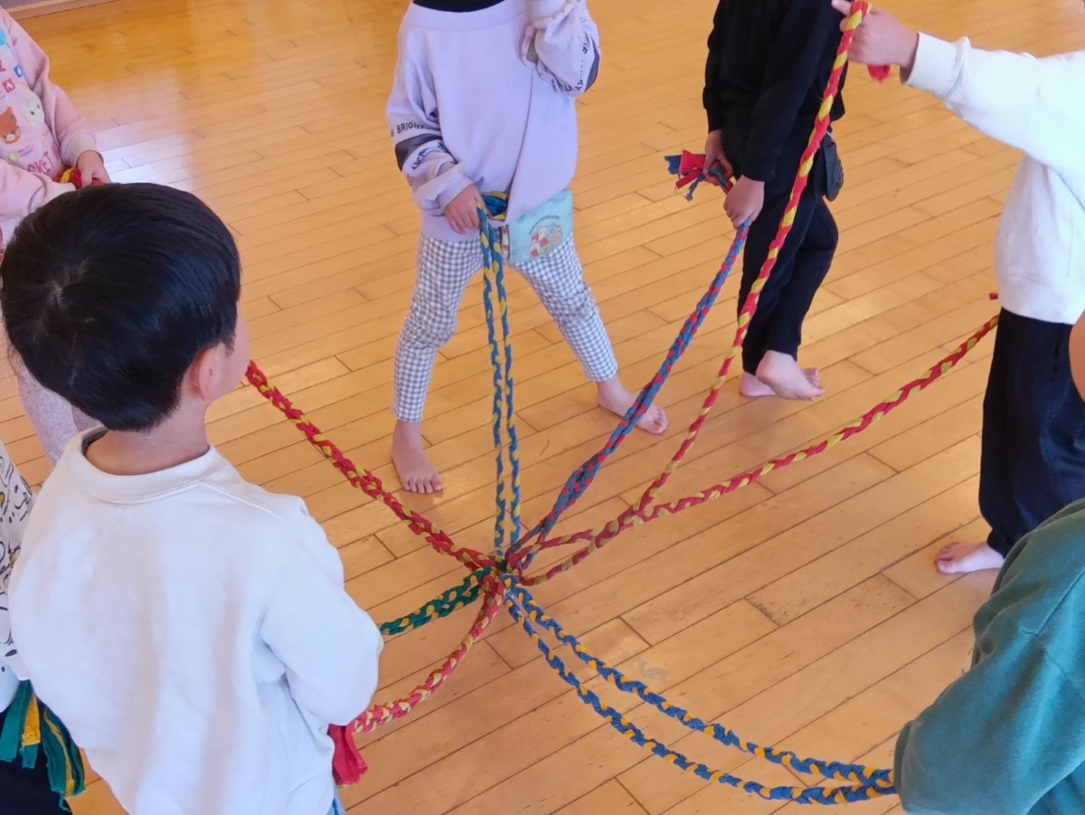 編んだ縄跳びをつなげ、輪になる子どもたち