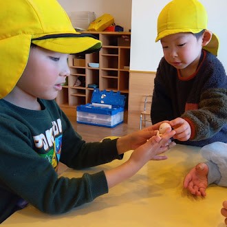 胎児人形に優しく触れる子どもたち